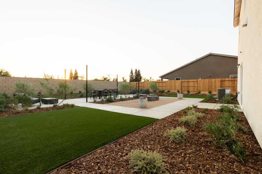 A backyard with a brick path.