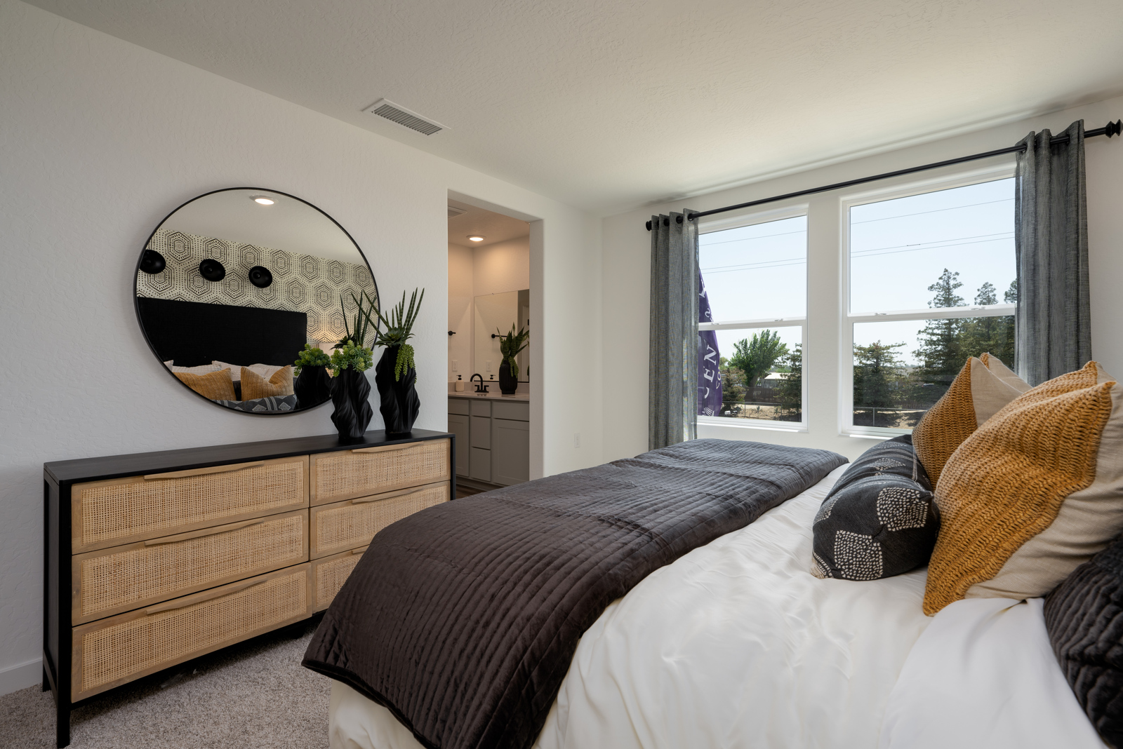 A bedroom with a large mirror.