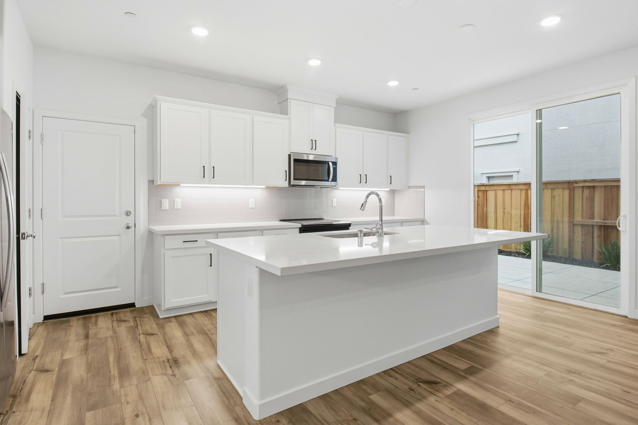 A kitchen with white cabinets.