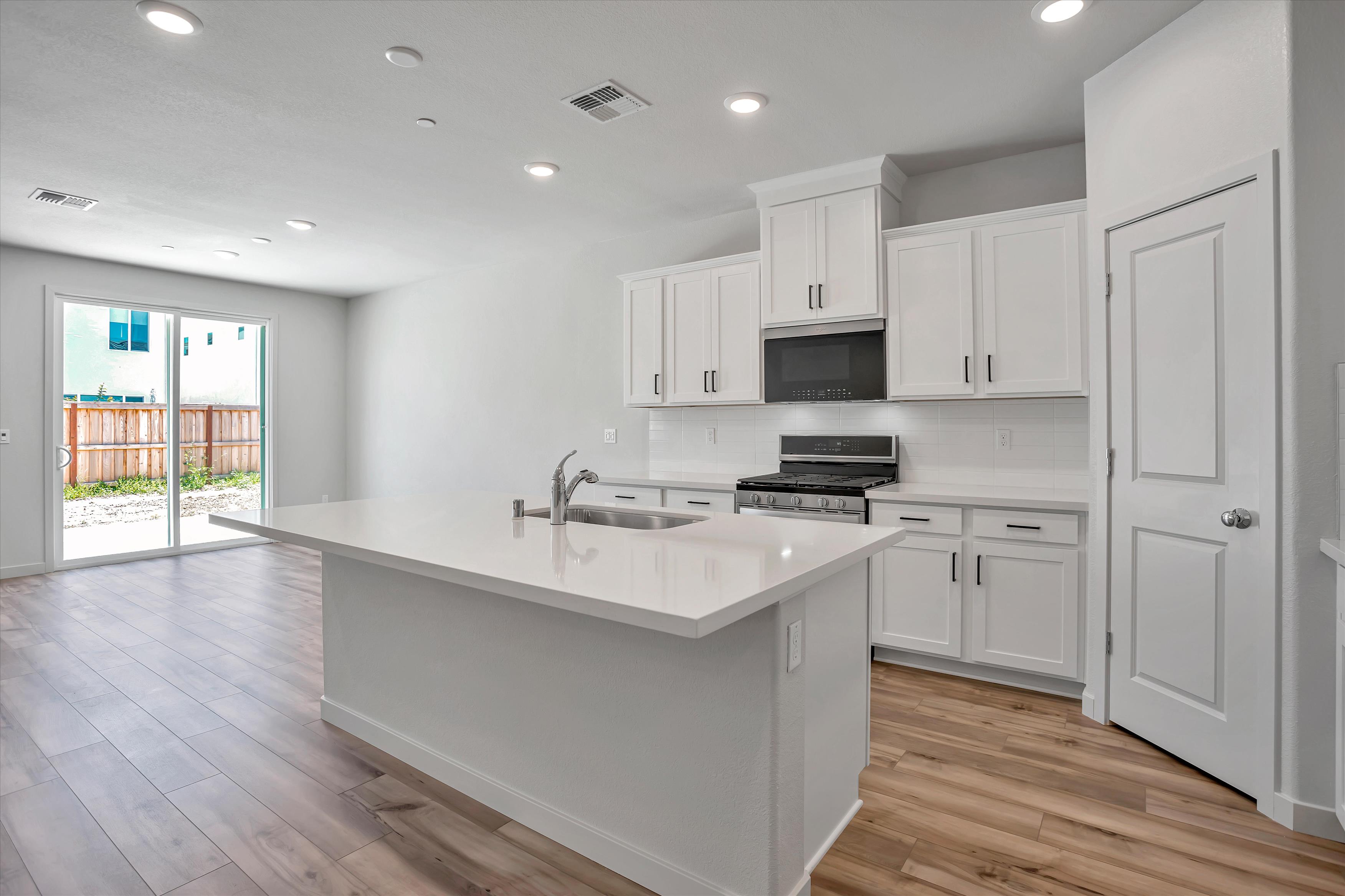 A kitchen with white cabinets.