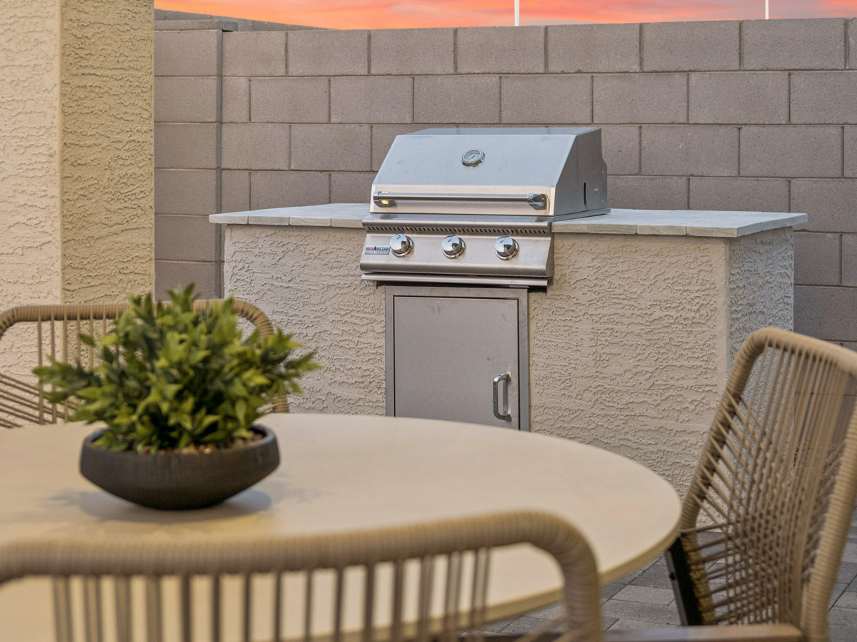A table with a potted plant and a grill on it.