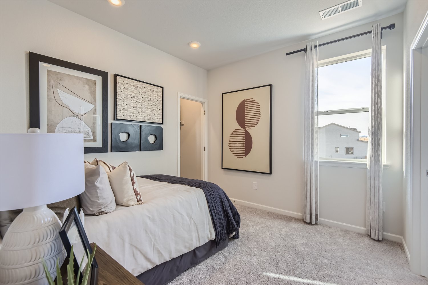 A bedroom with a bed and a lamp.