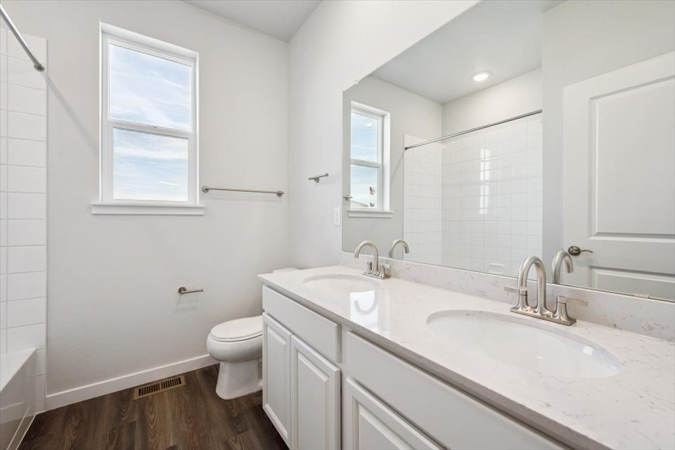 A bathroom with a tub sink and toilet.