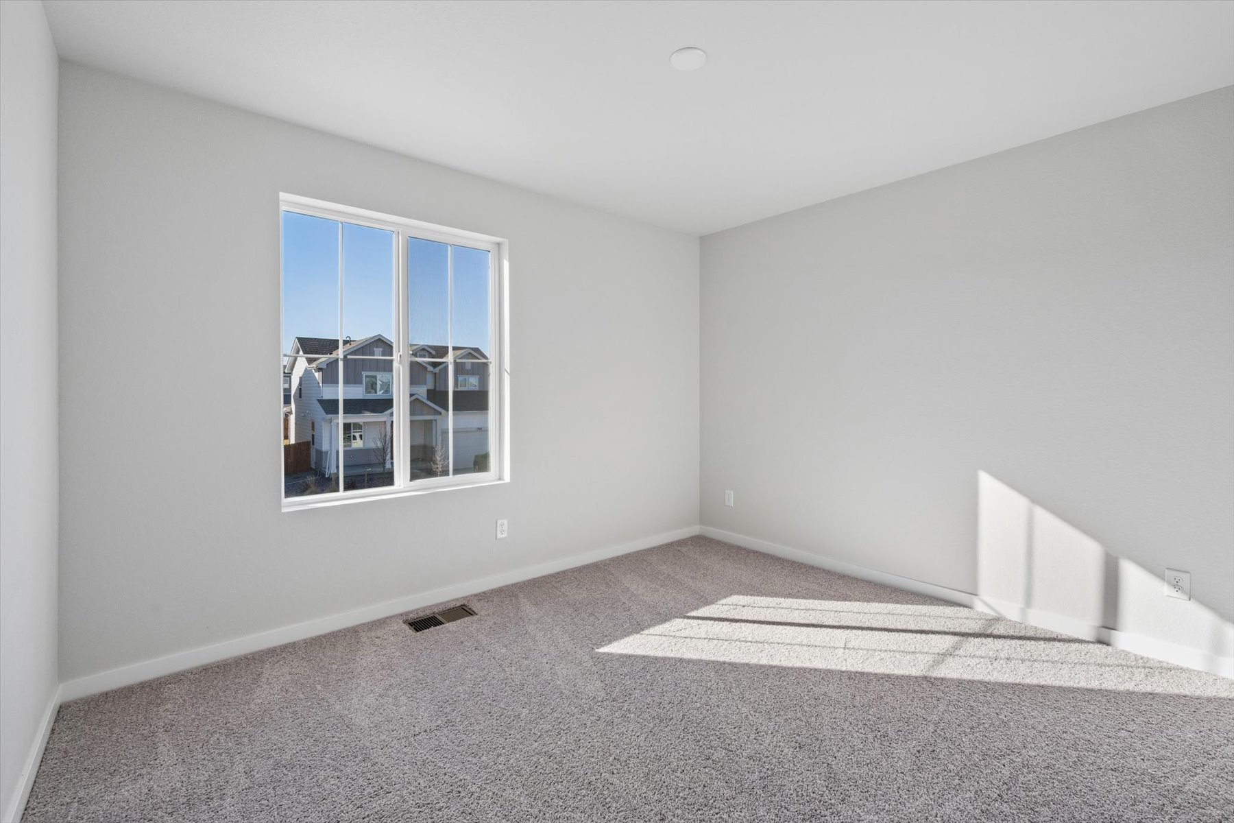 A room with a window and a rug.