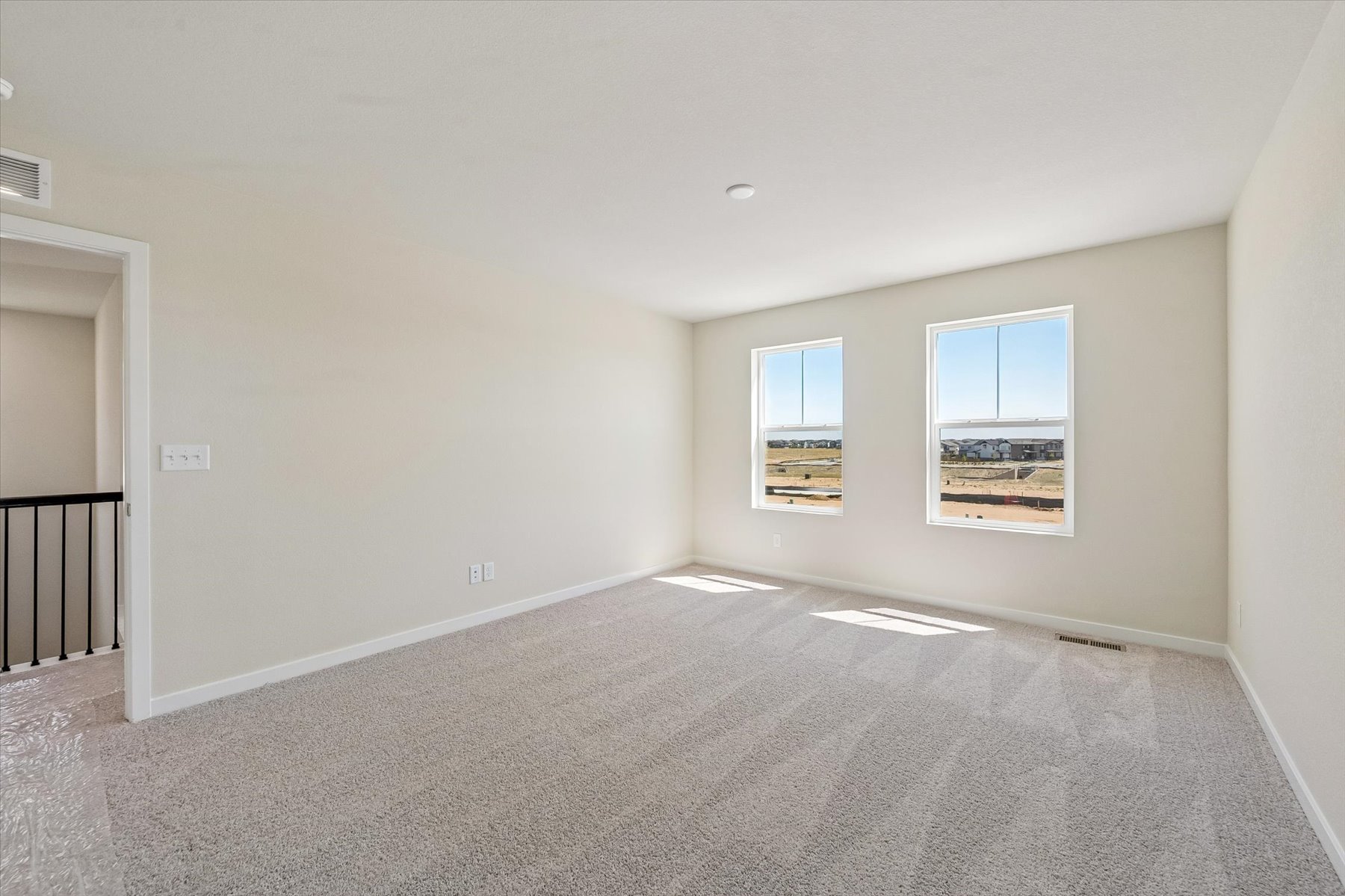 A room with a carpet and windows.