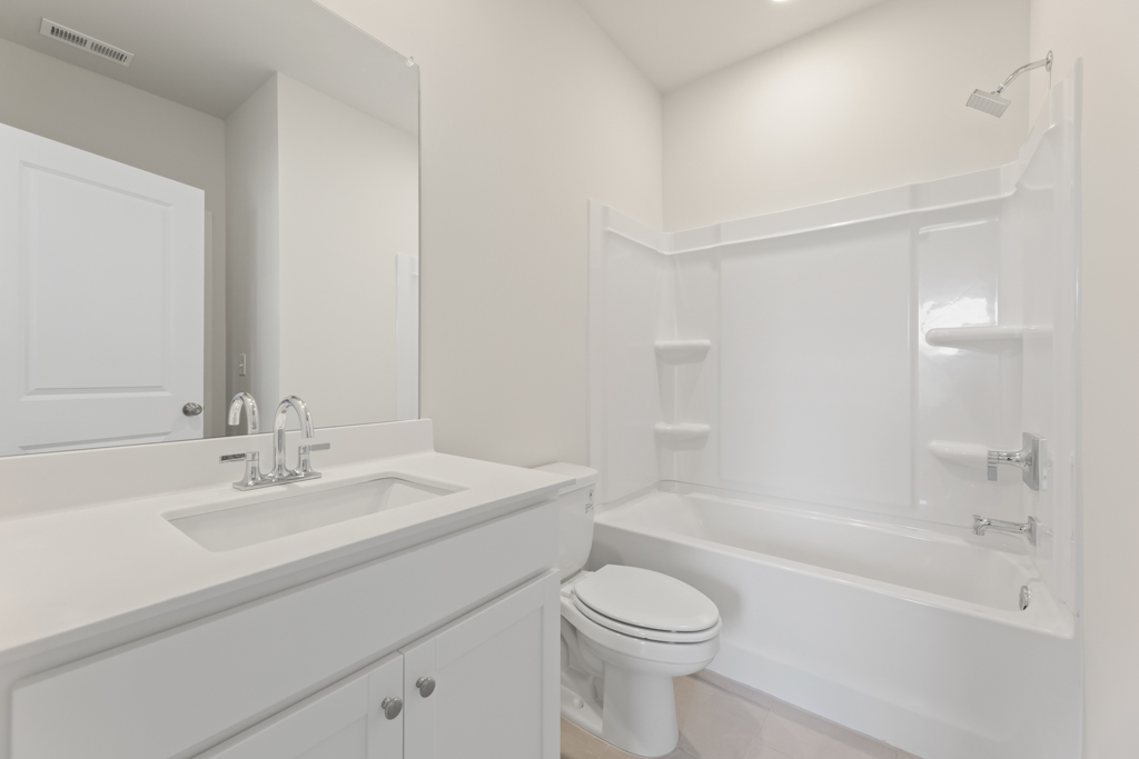 A bathroom with a tub sink and toilet.