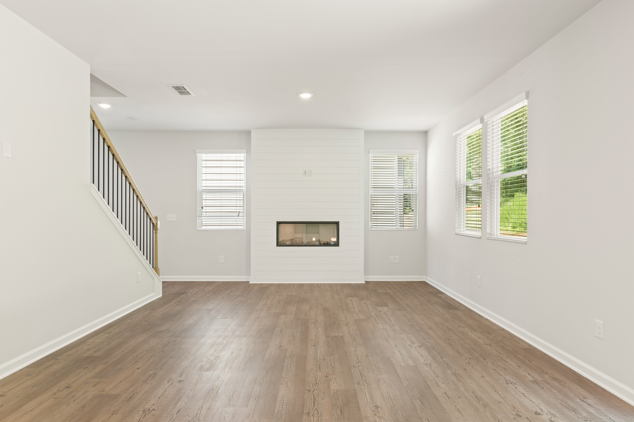 A room with a wood floor and white walls.