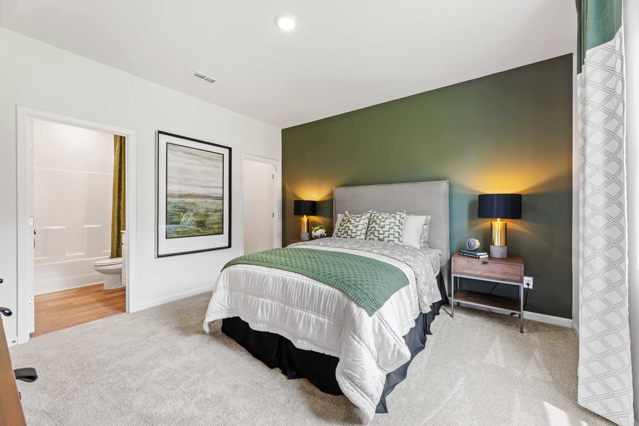 A bedroom with a bed and lamps.