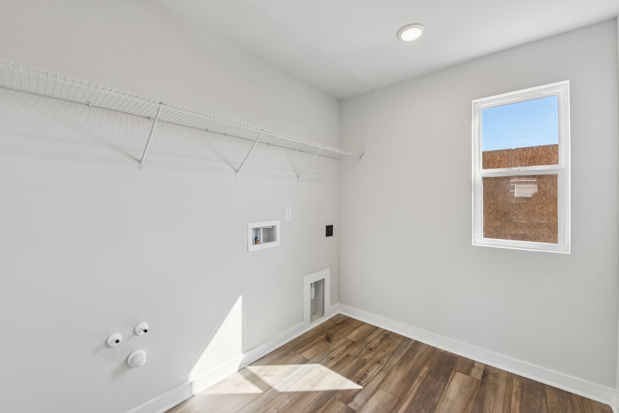 A room with a wood floor and a window.
