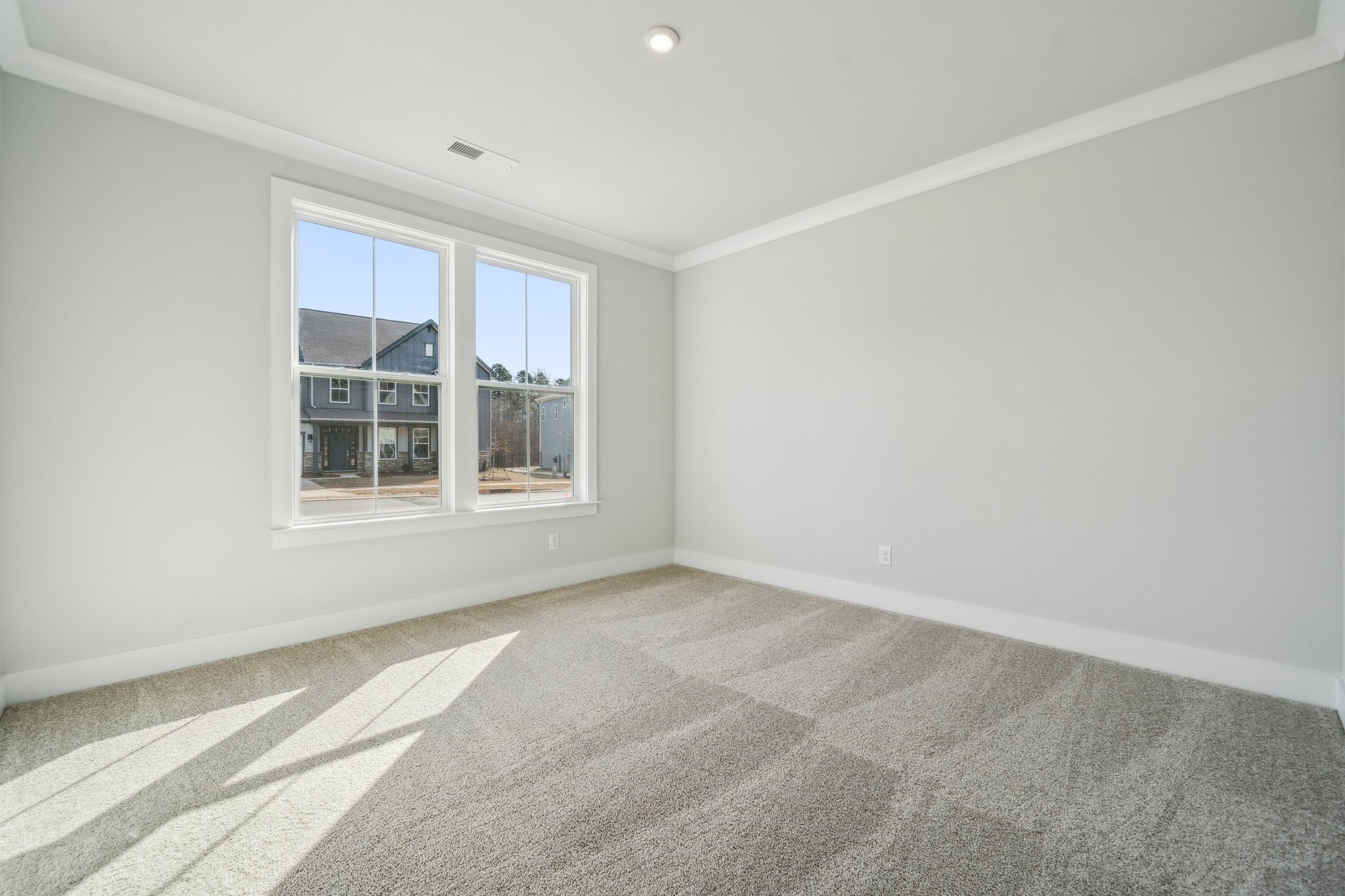 A room with a window and a rug.
