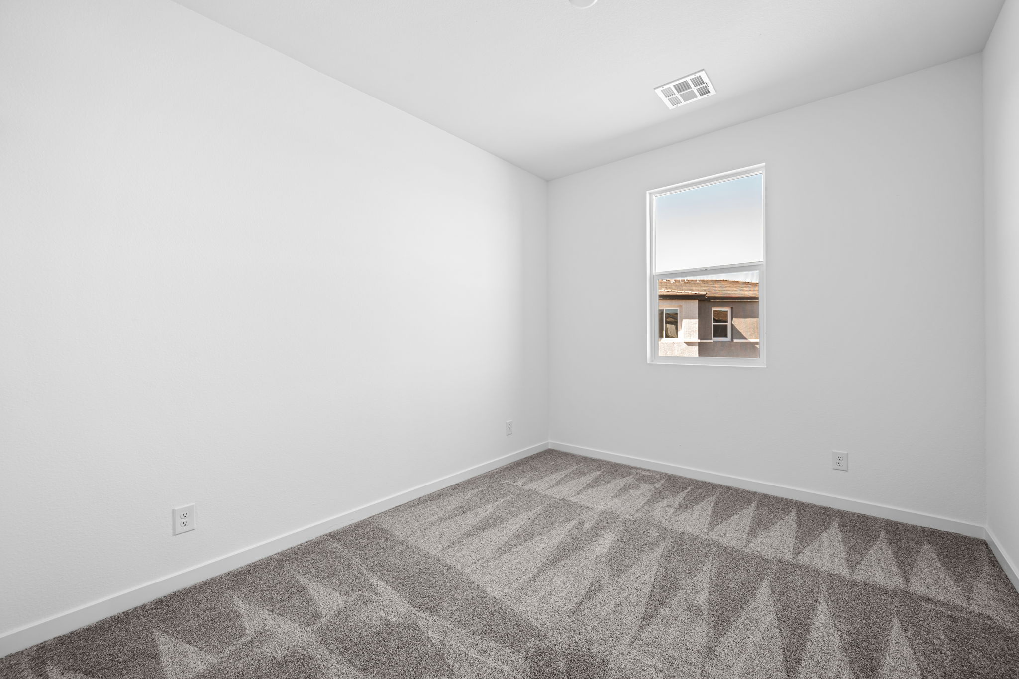 A room with a carpet and a window.