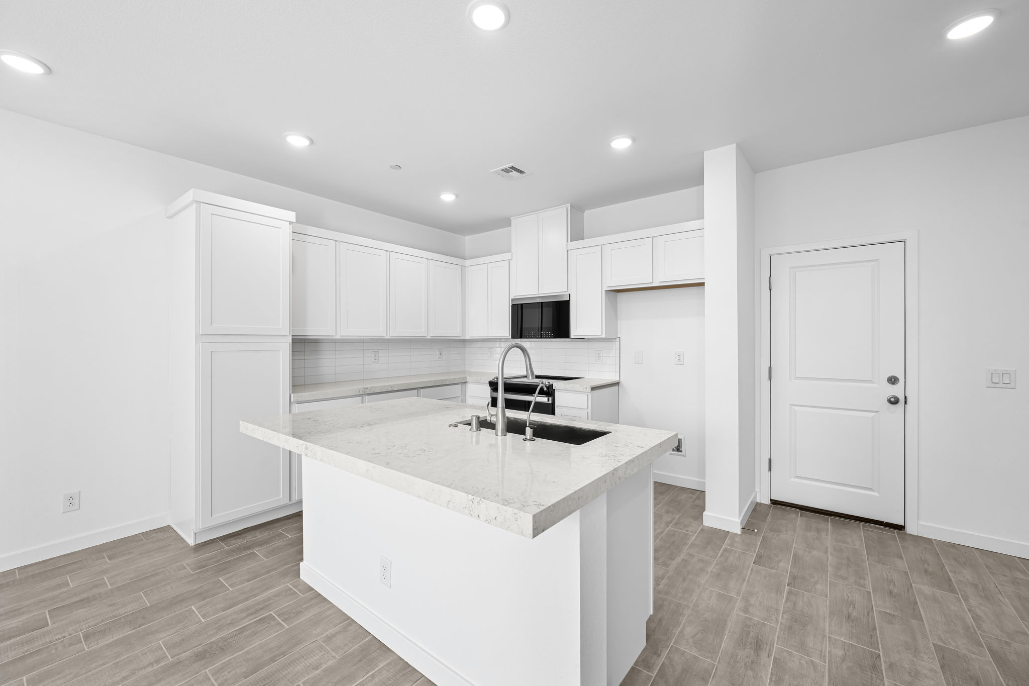 A kitchen with white cabinets.