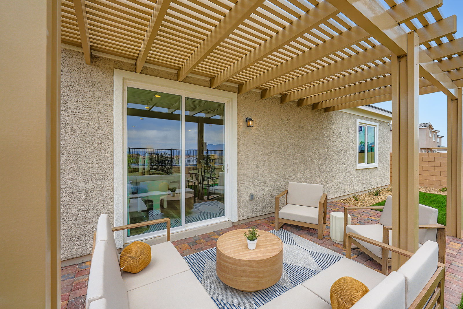 A room with a glass door and a patio with a table and chairs.