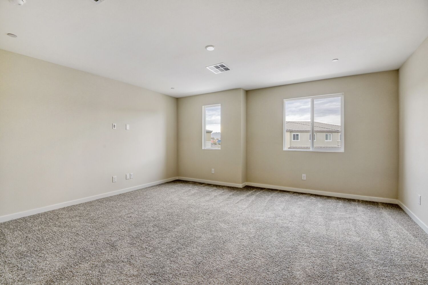 A room with a carpet and windows.