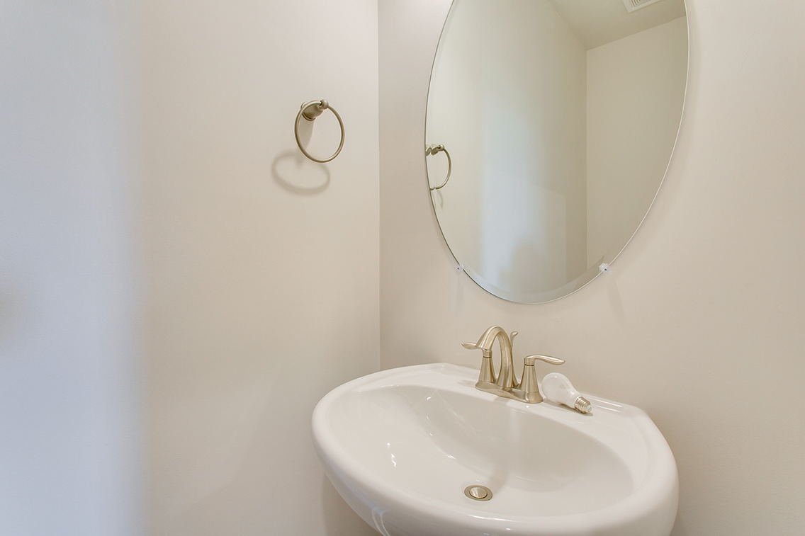 A bathroom with a round mirror.
