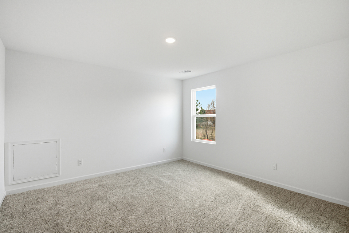 A room with a window and a carpet.