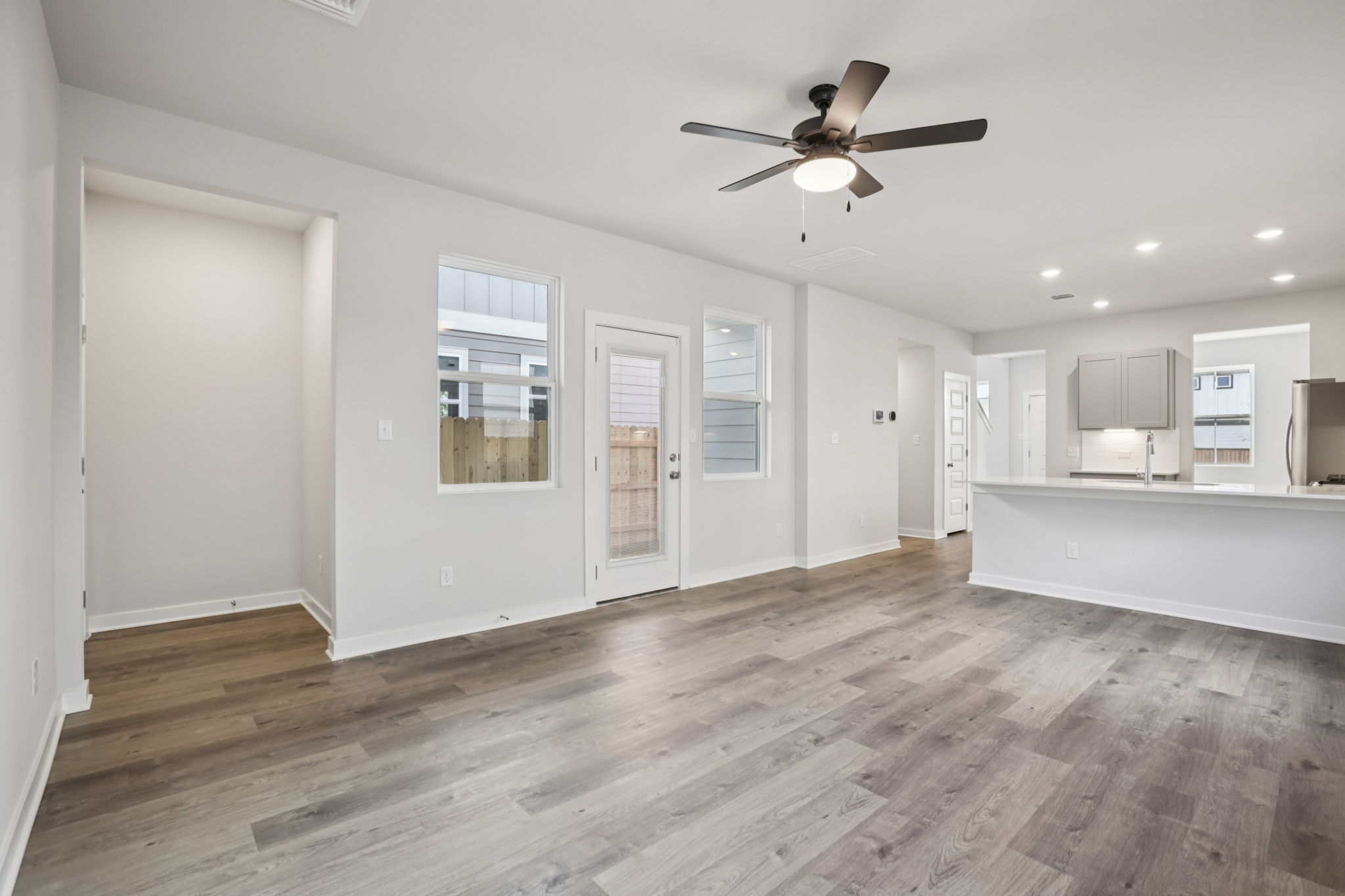 A room with white walls and a ceiling fan.