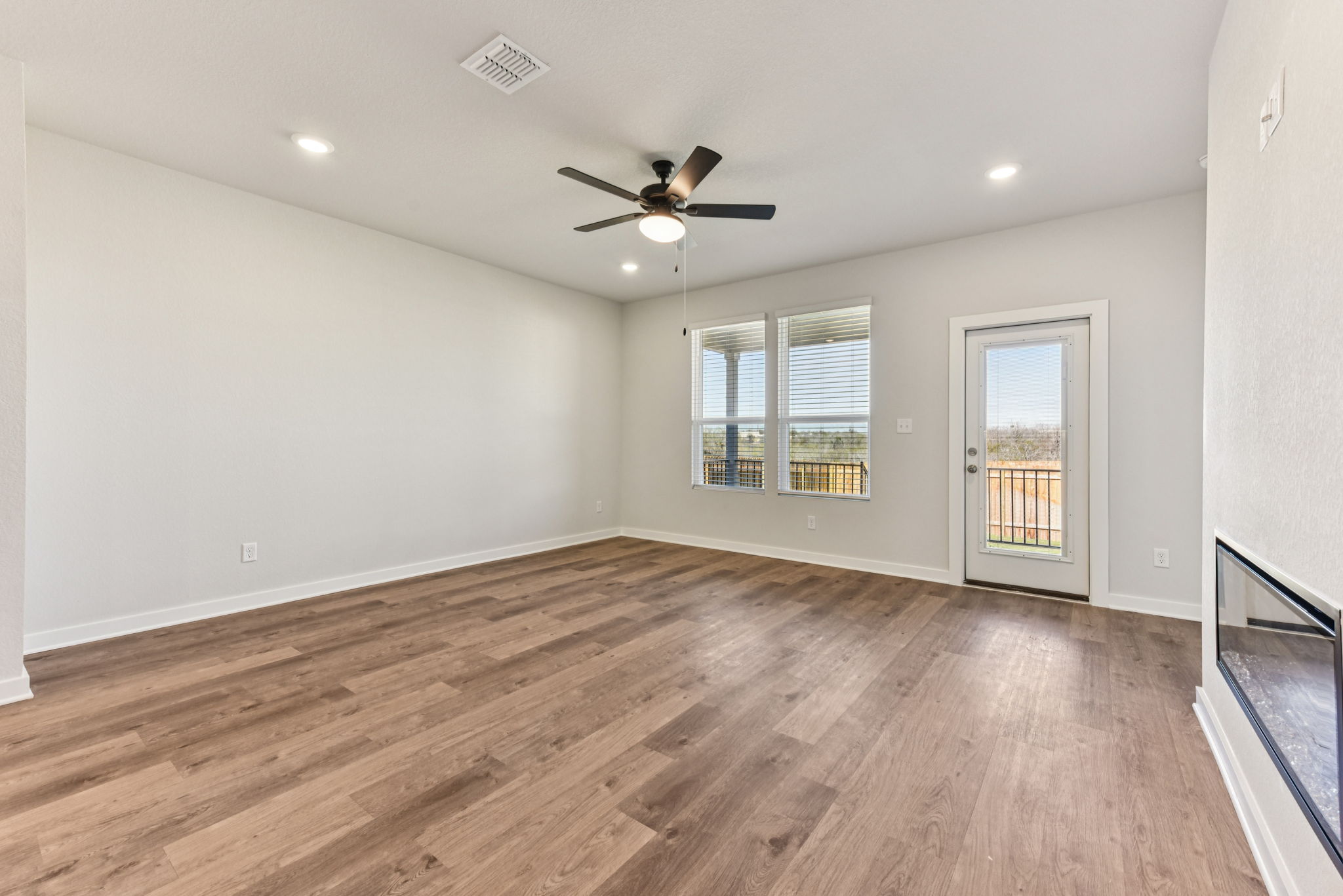 A room with a wood floor and a ceiling fan.