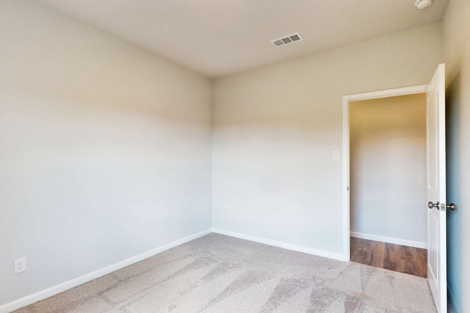 A room with a carpet and a door.