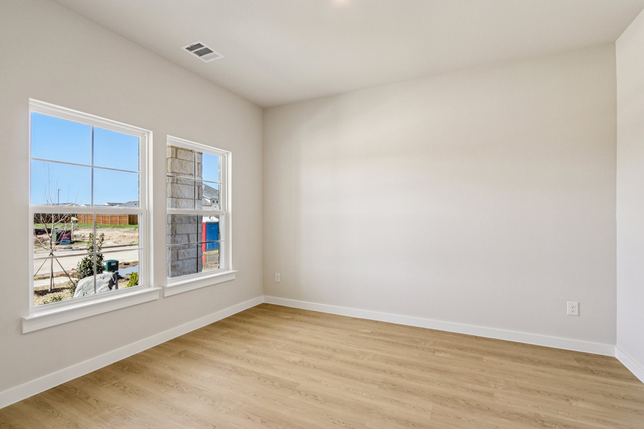 A room with a wood floor and a window with a wood floor.