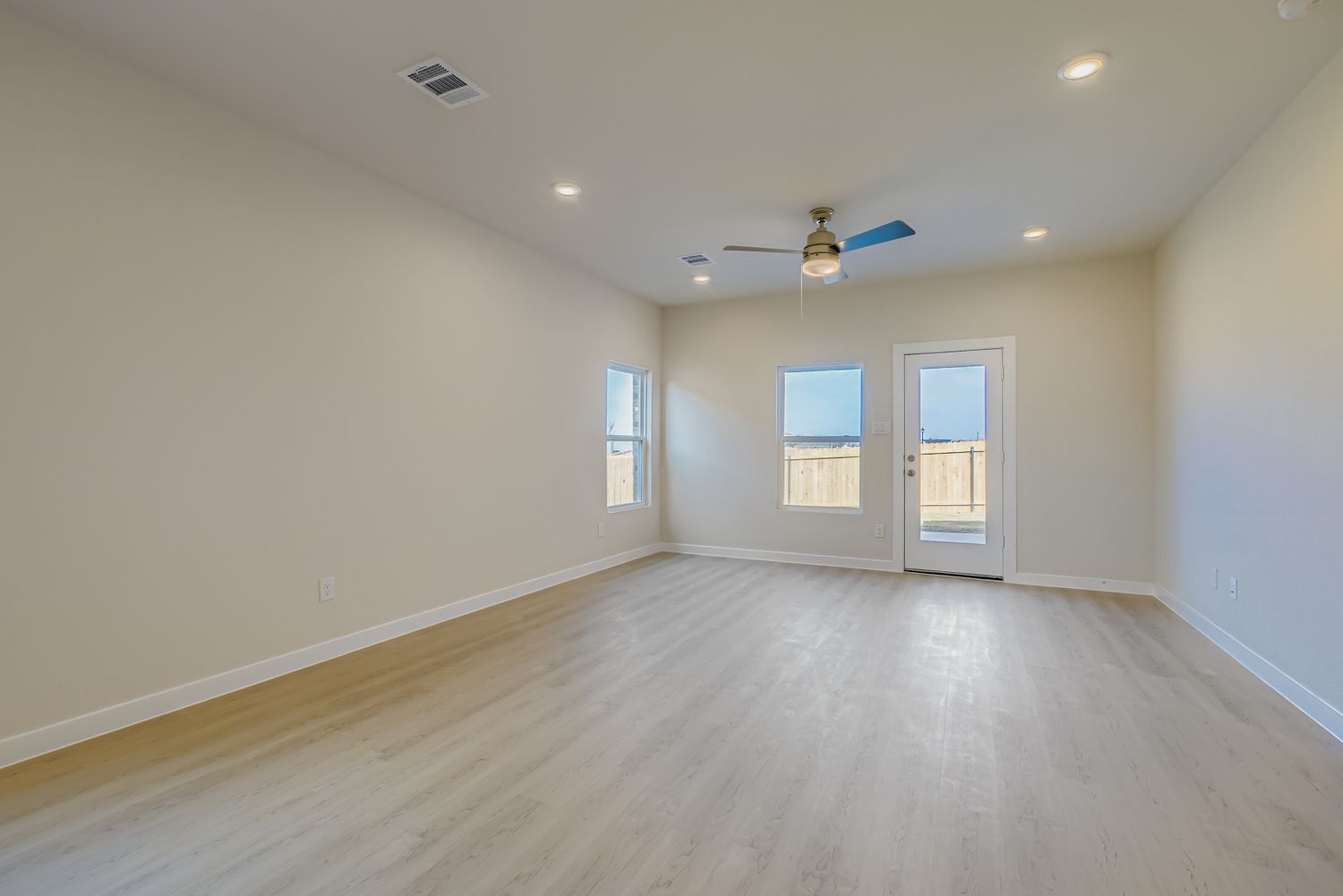 A room with a wood floor and a ceiling fan.