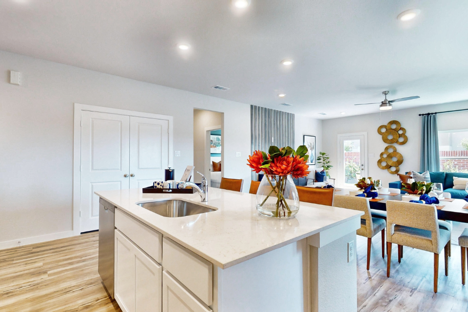 A kitchen with a dining table and chairs.