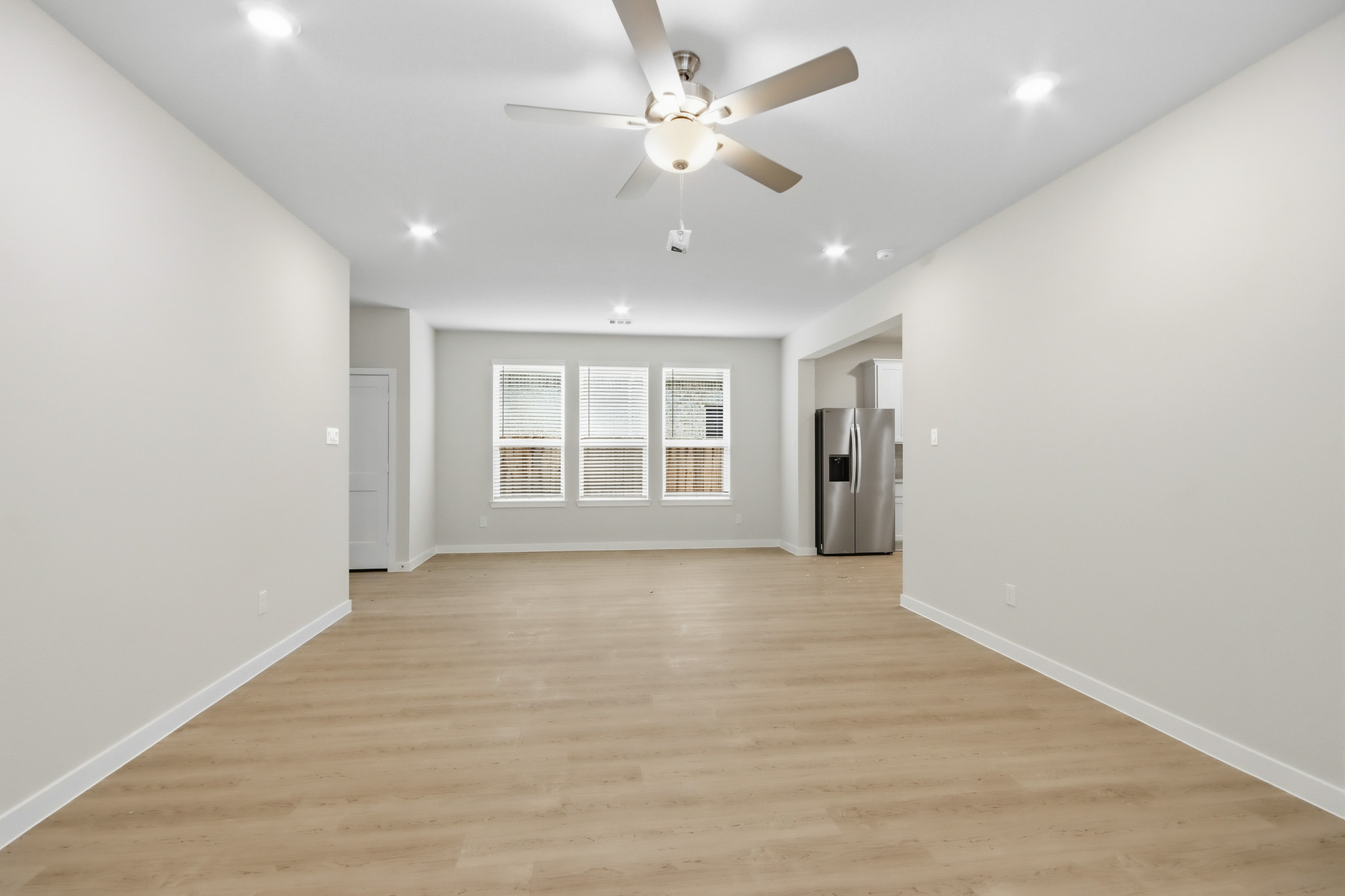 A room with a wood floor and a ceiling fan.