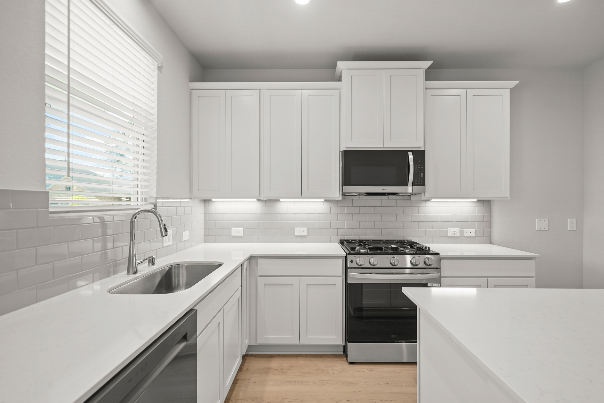 A kitchen with white cabinets.