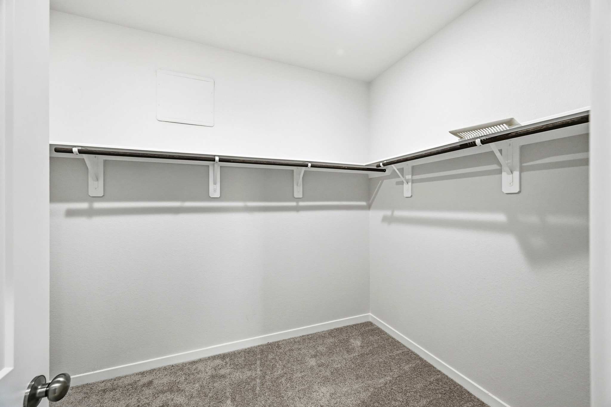 A white wall with a metal bar.