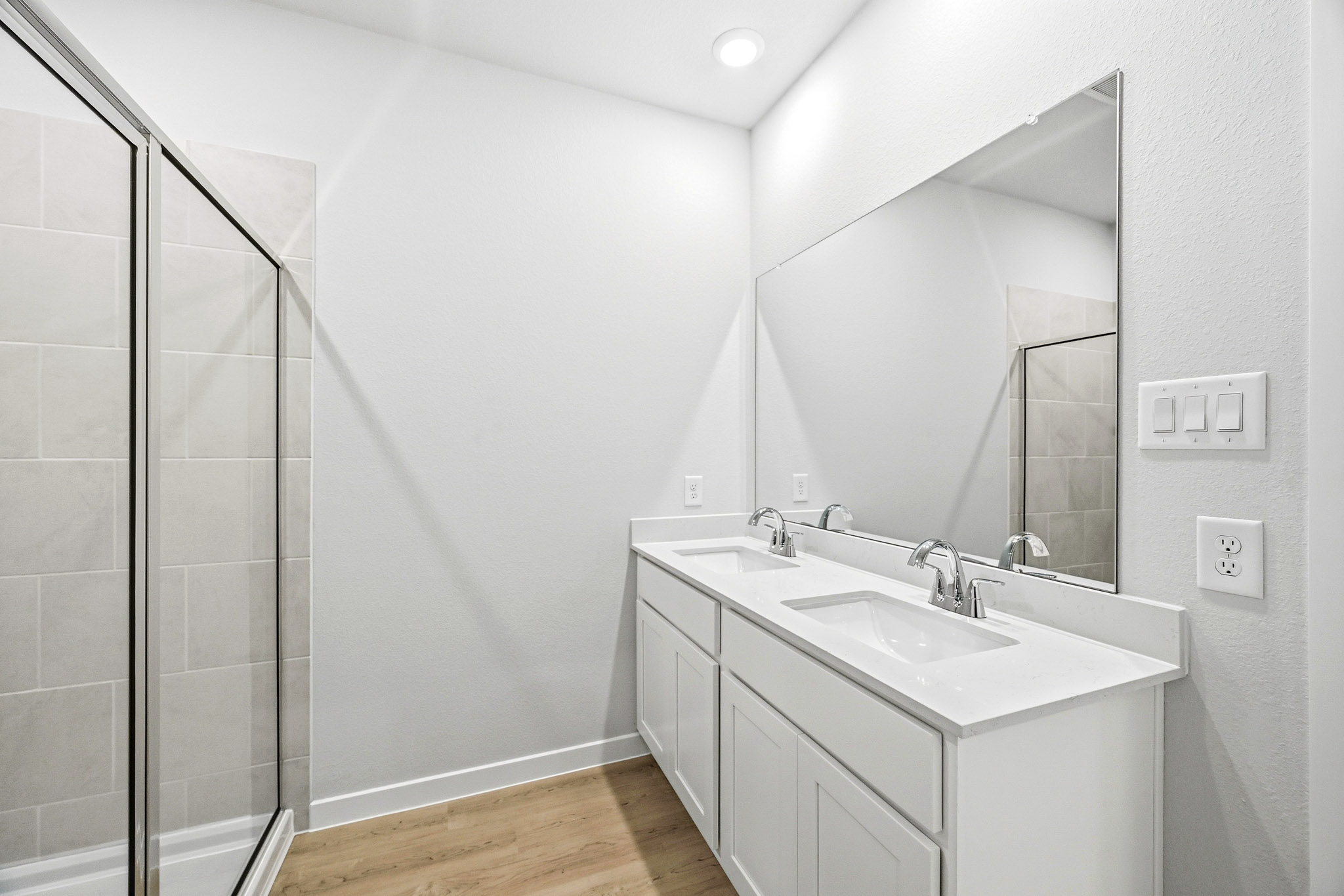 A bathroom with a sink and a shower unit.