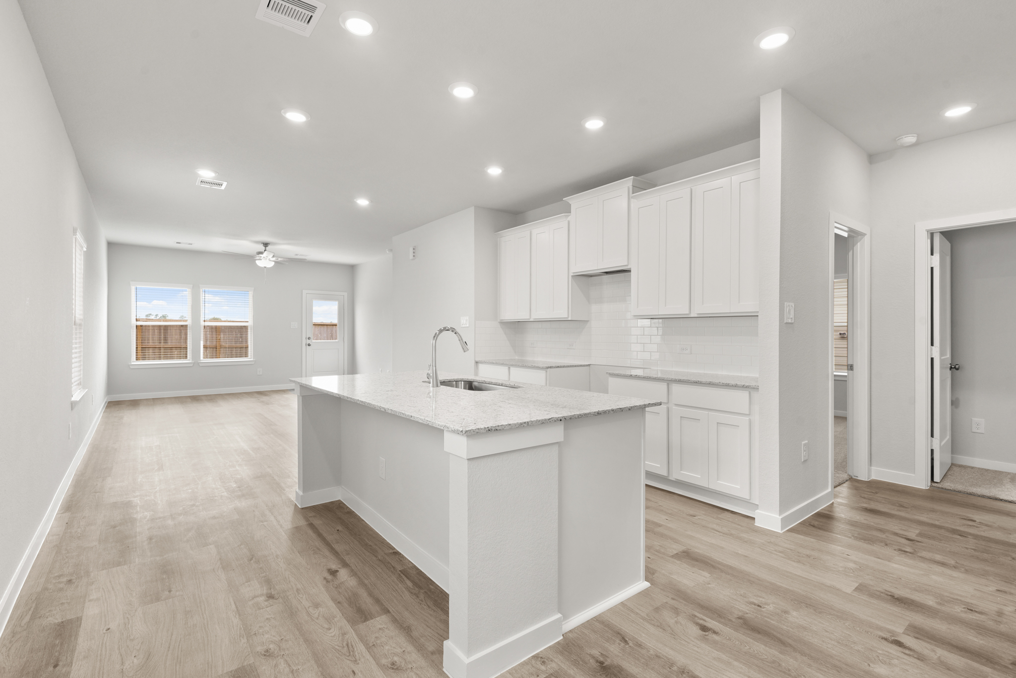 A kitchen with white cabinets.