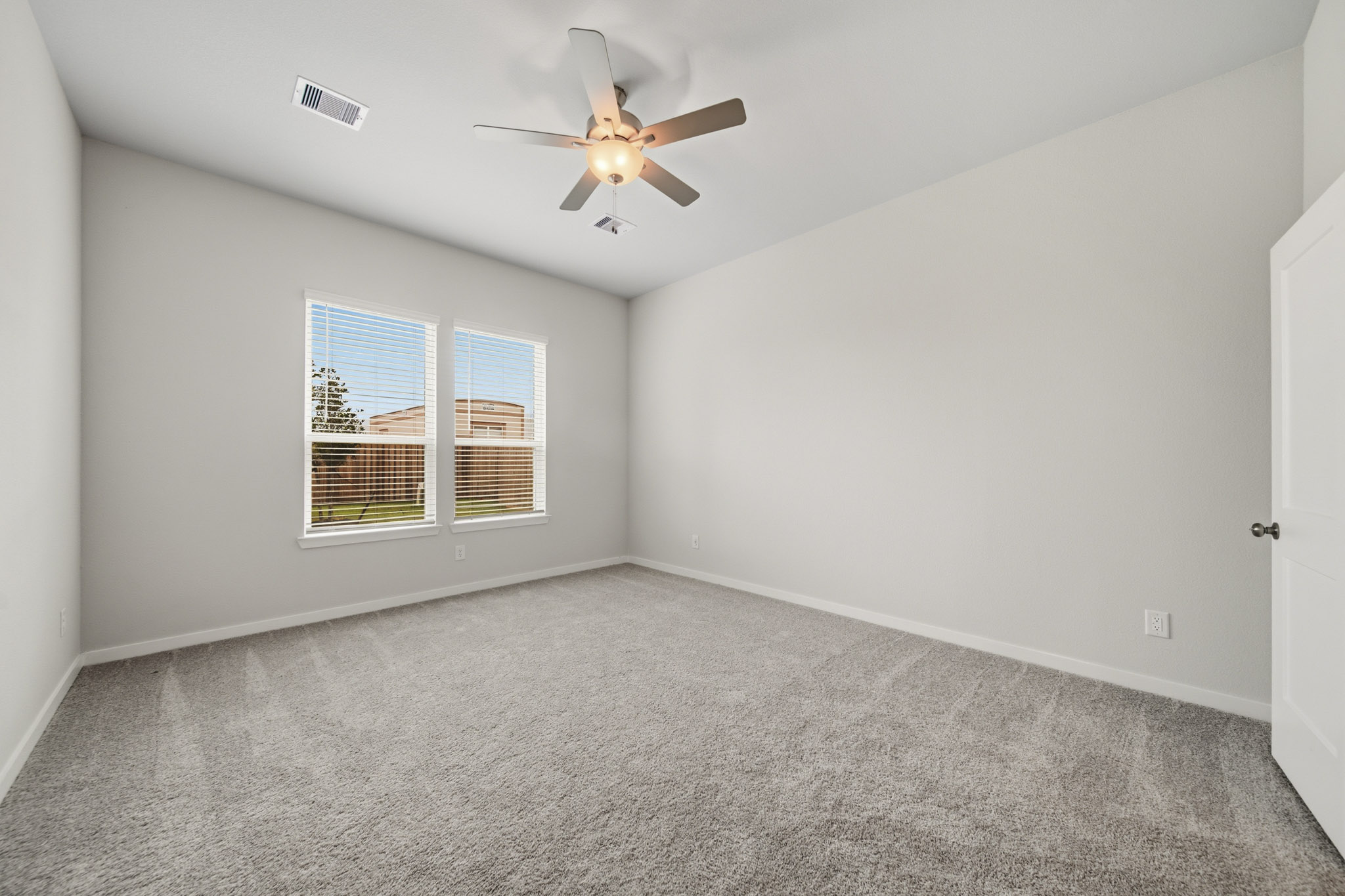 A room with a ceiling fan and a window.