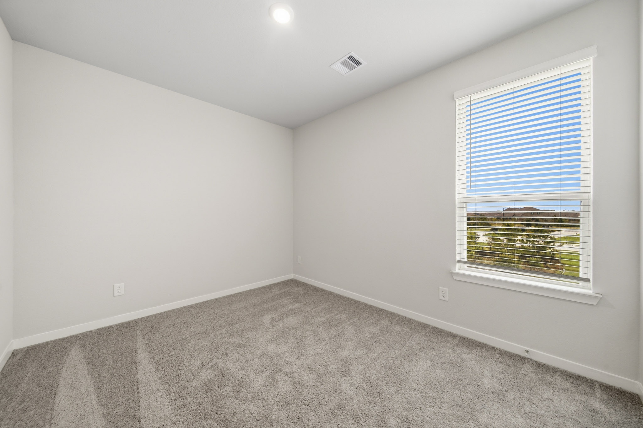A room with a window and a carpet.