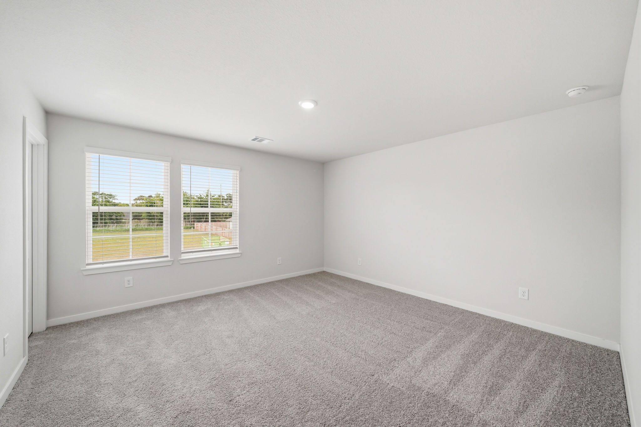 A room with a window and a carpet.