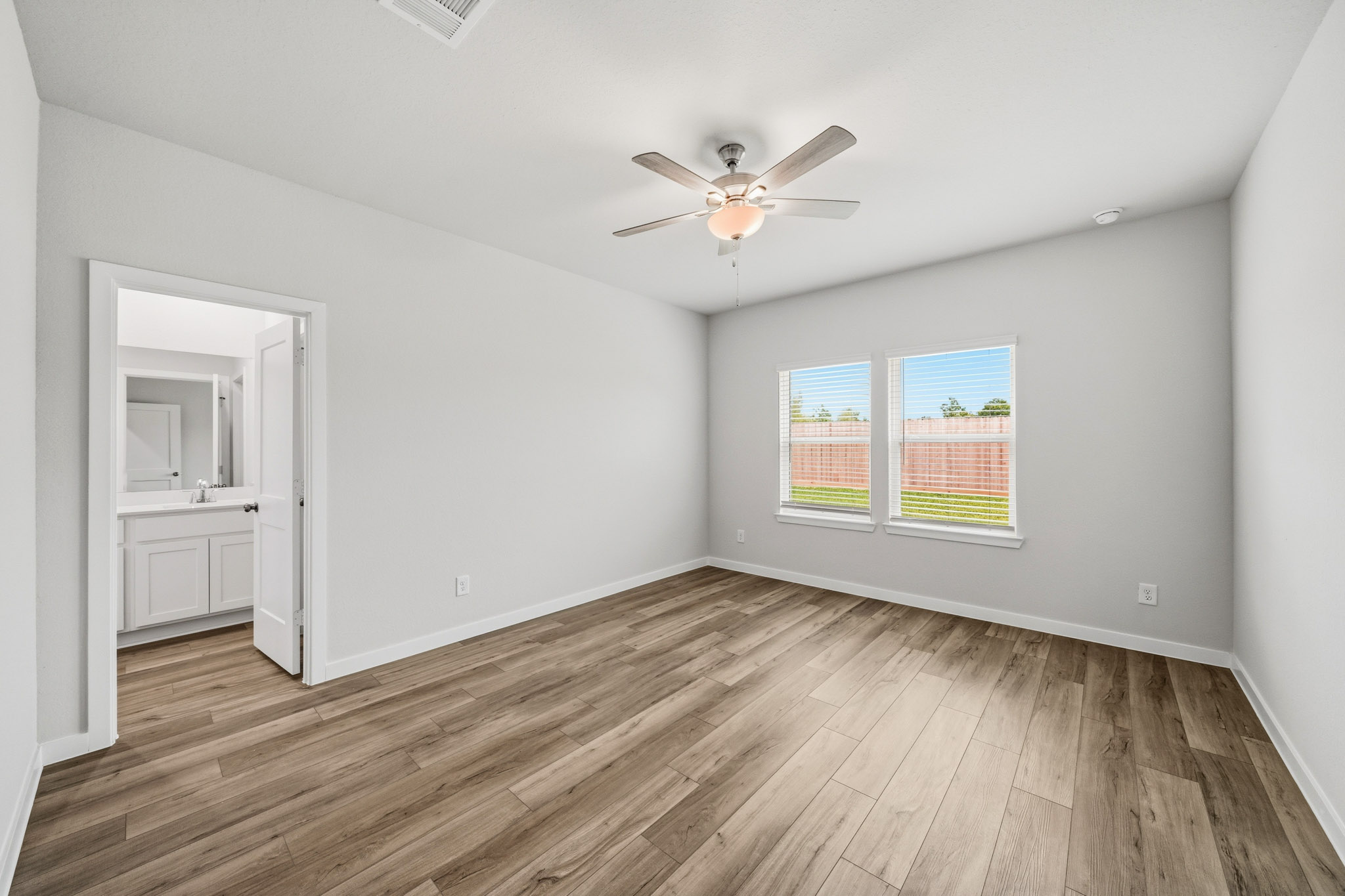 A room with a wood floor and a ceiling fan.