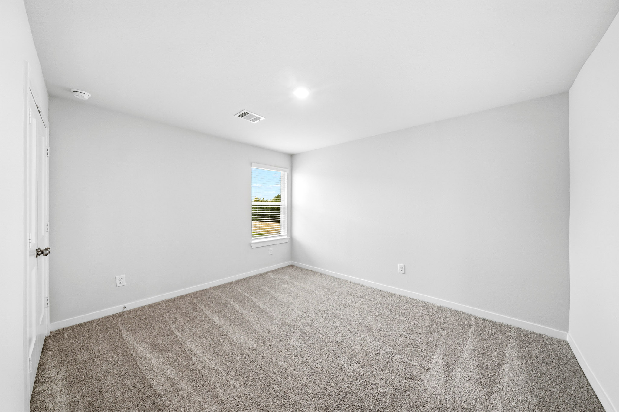 A room with a carpet and a window.