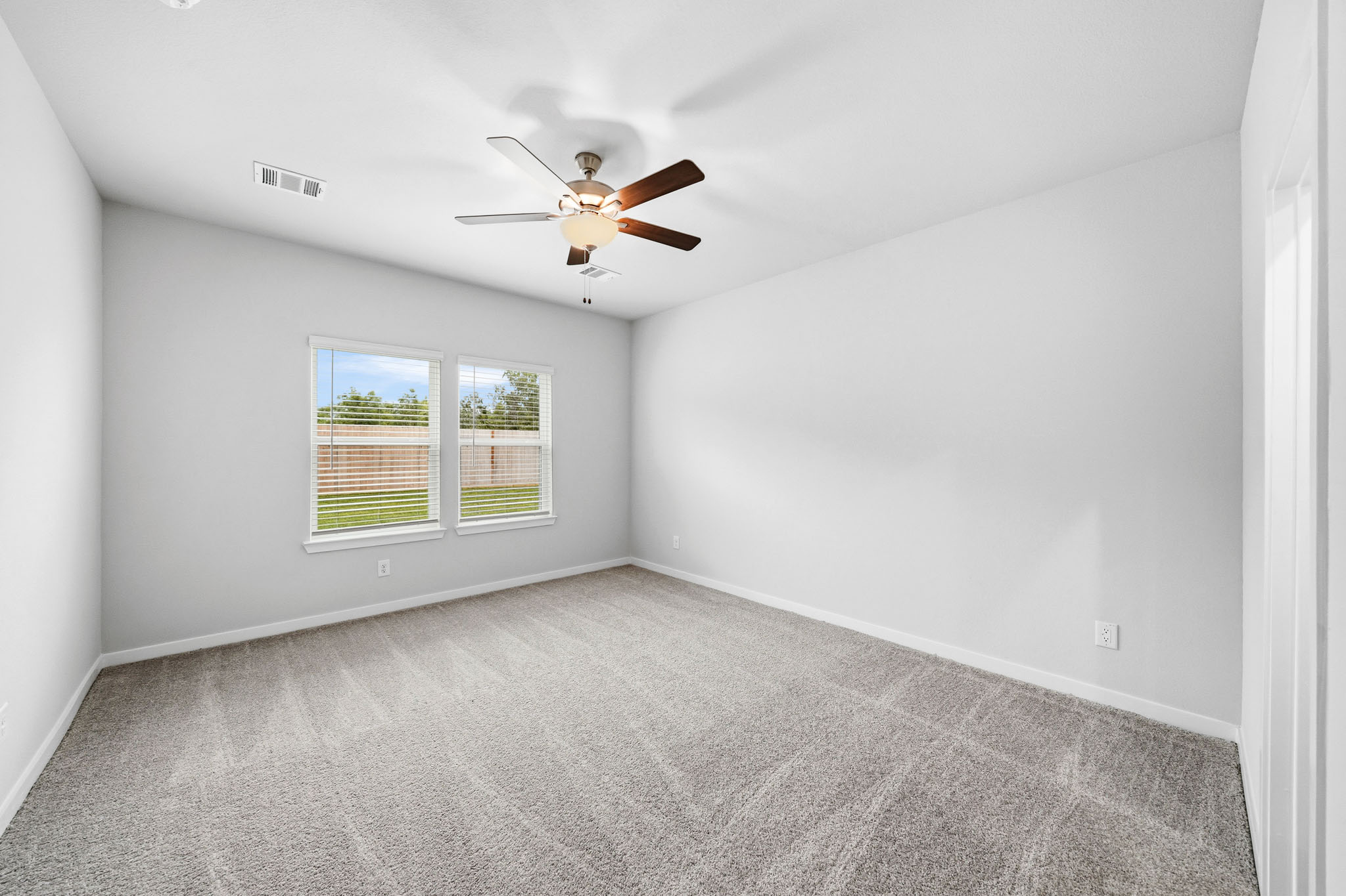 A room with a ceiling fan and a window.