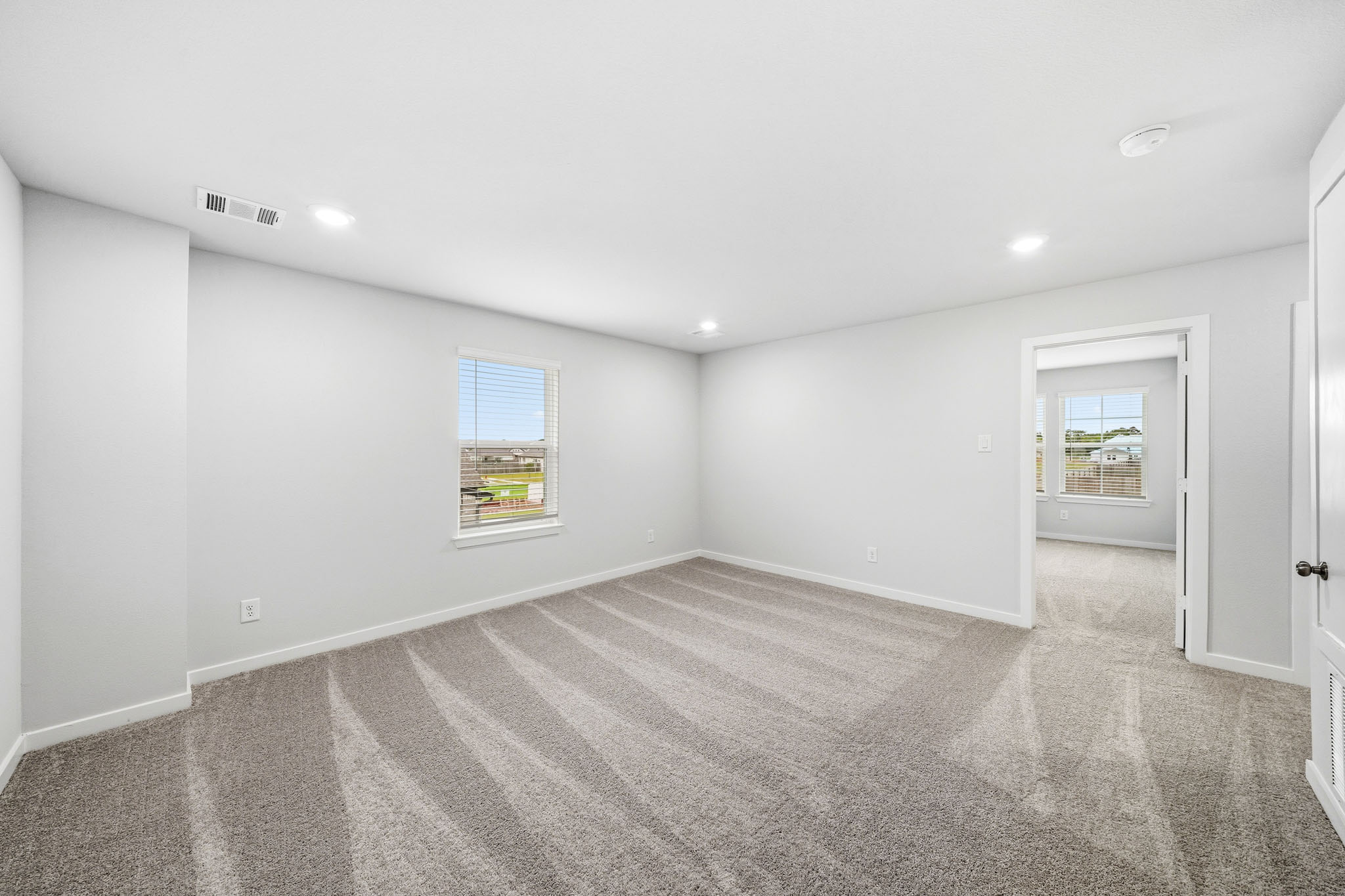 A room with a carpet and a window.