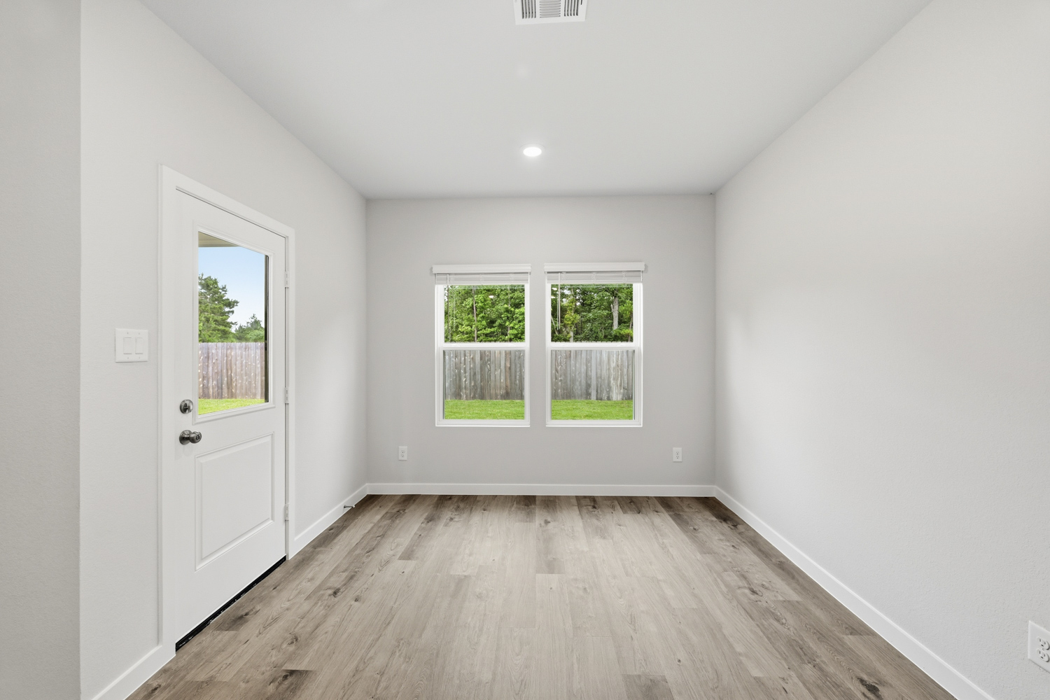 A room with a wood floor and a window with a wood floor.