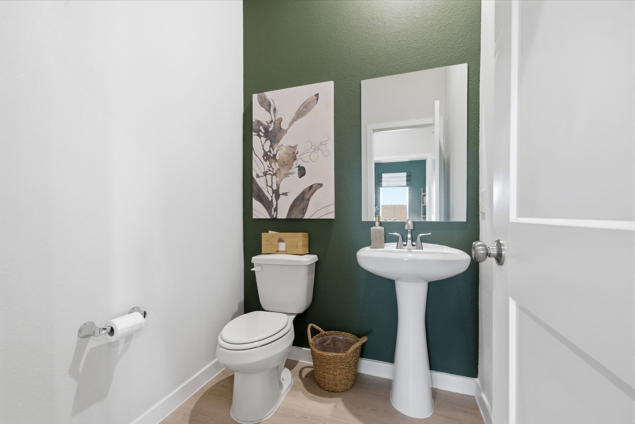 A bathroom with a sink toilet and a mirror.