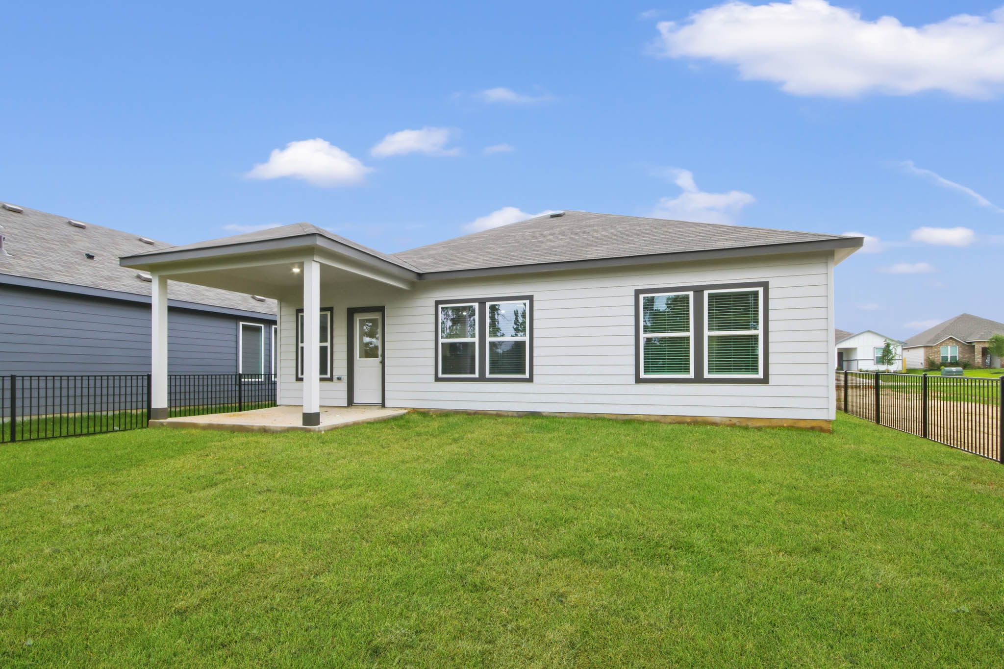 A house with a fence and grass.
