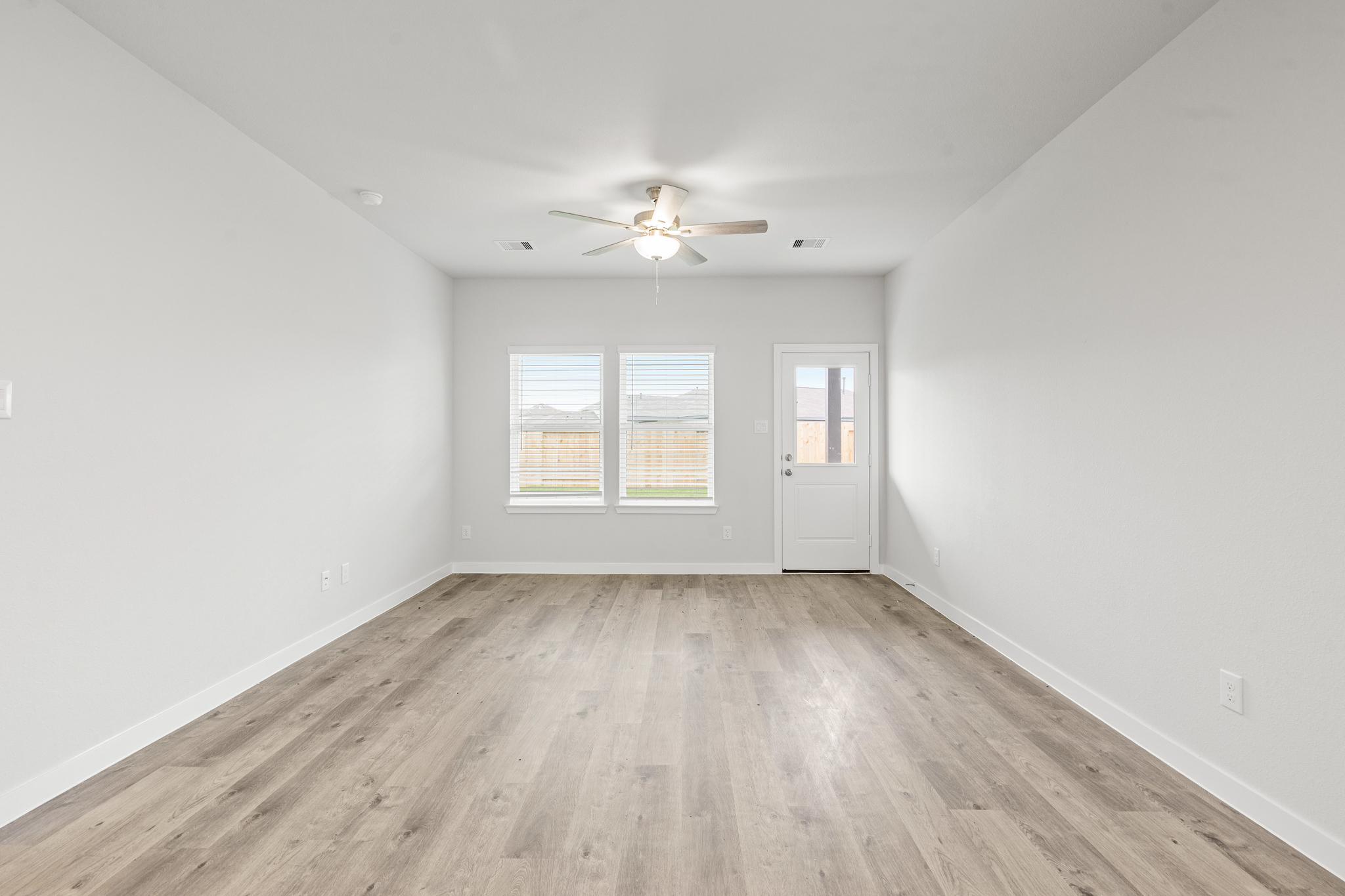 A room with a wood floor and a ceiling fan.