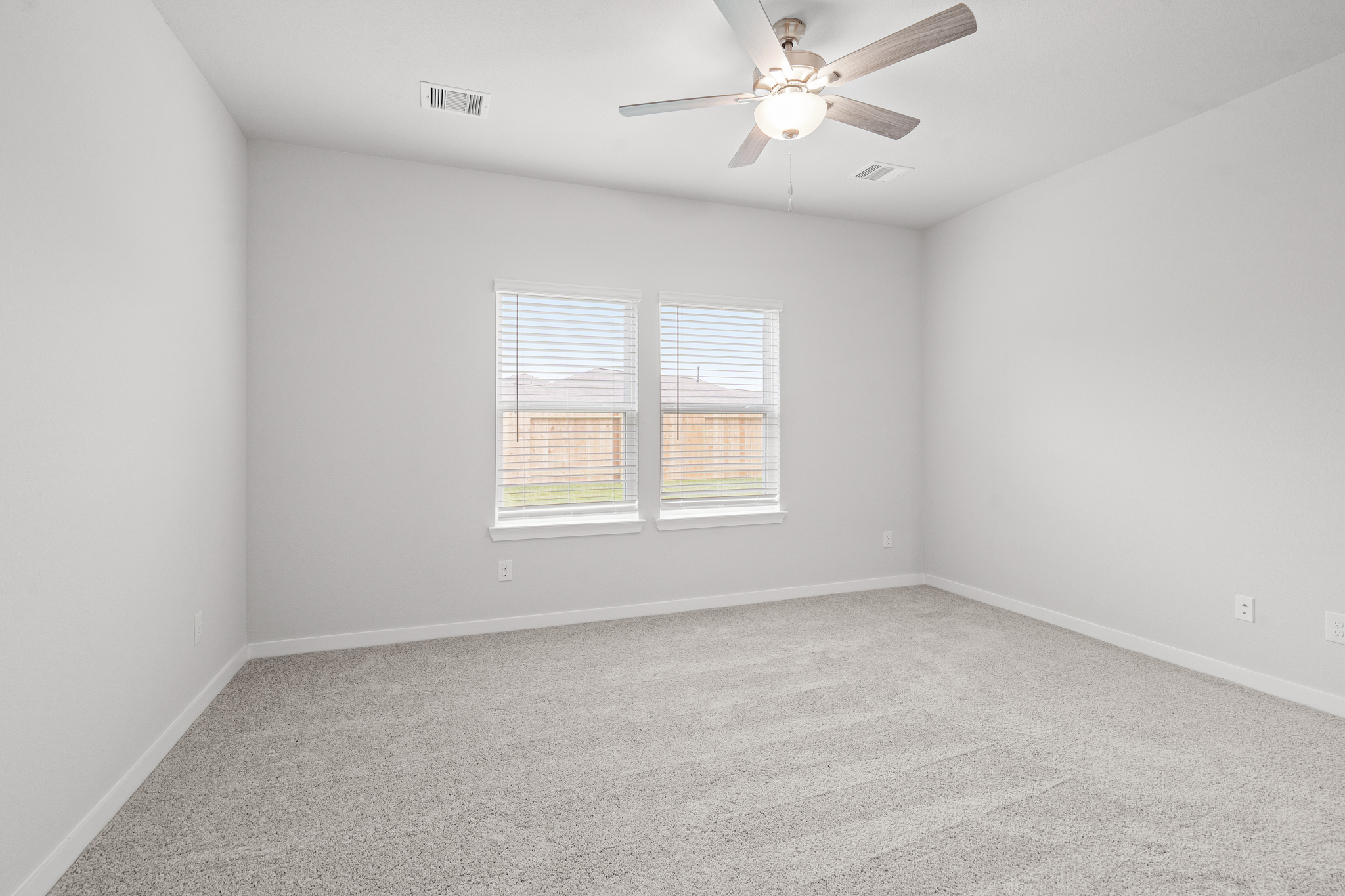 A room with a ceiling fan and a window.