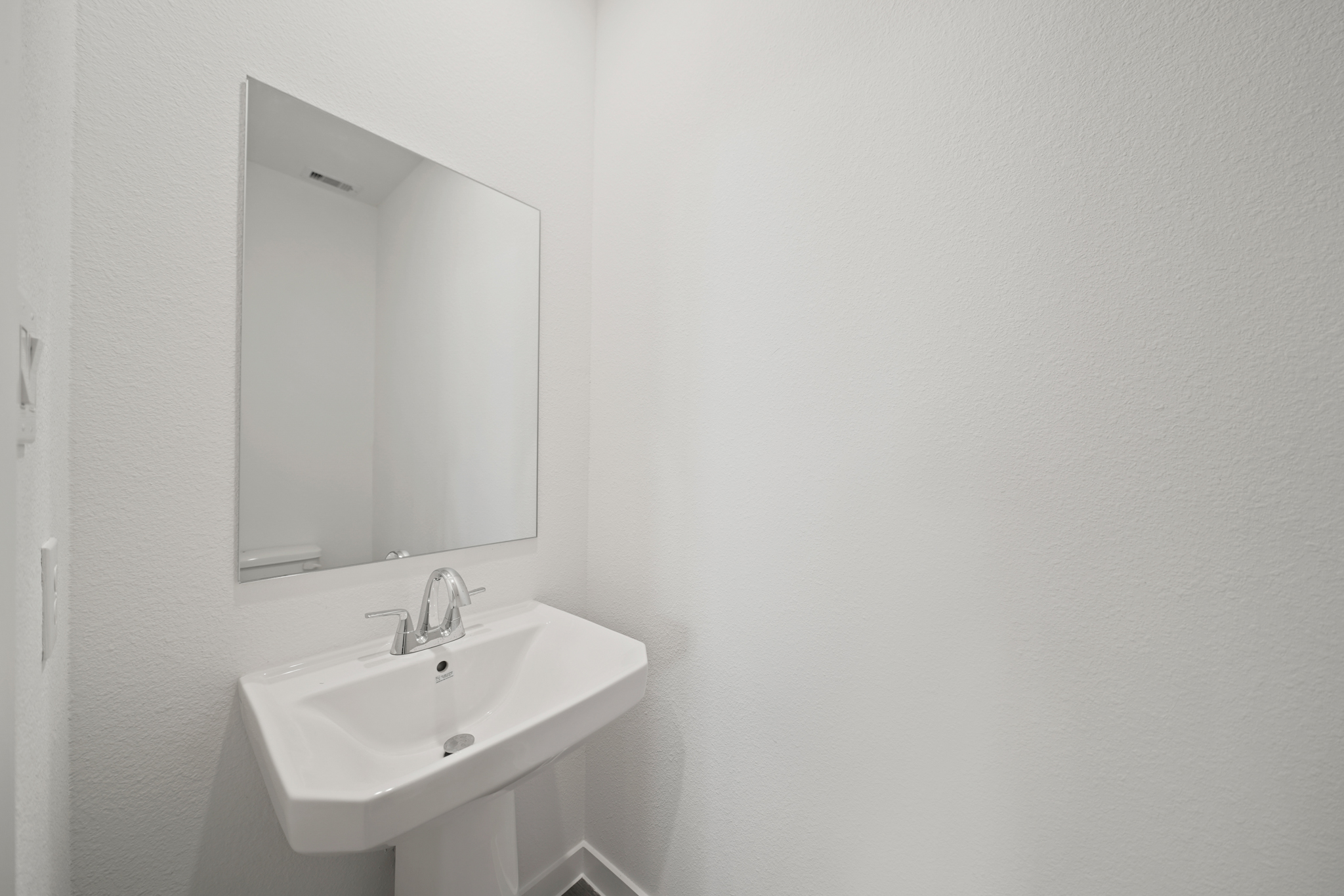 A bathroom with a mirror and sink.
