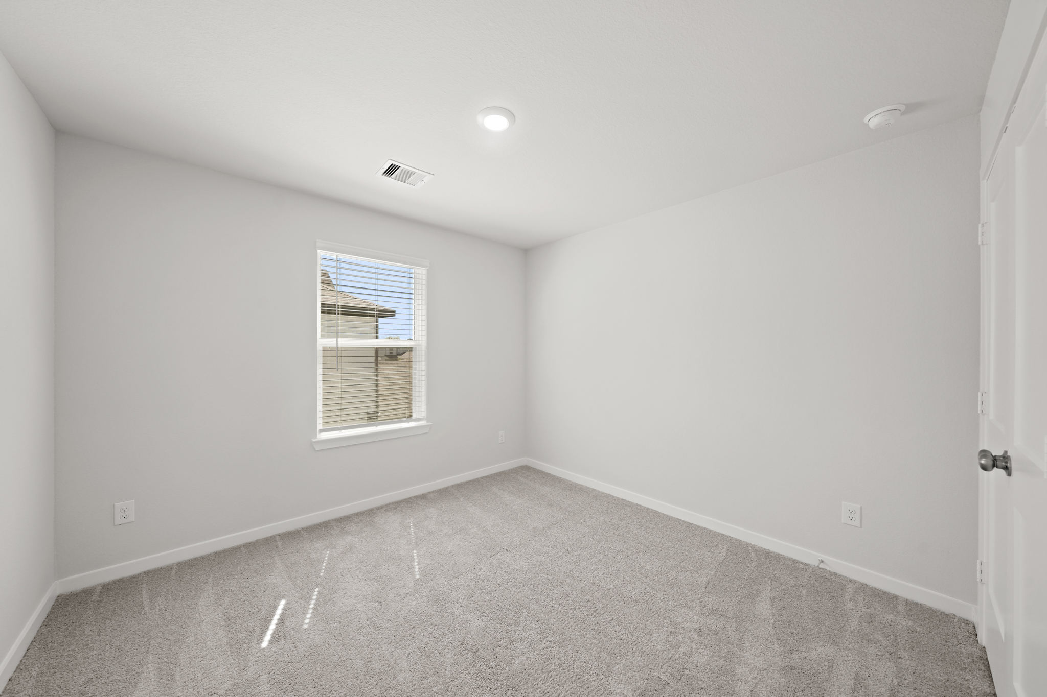 A room with a window and a carpet.