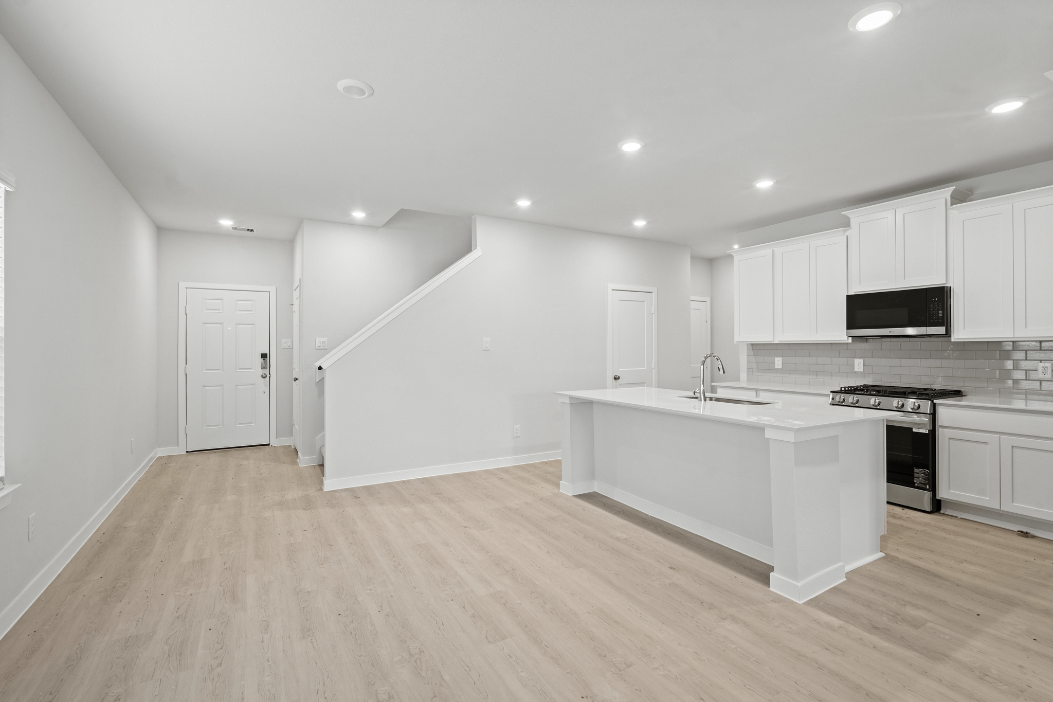 A kitchen with white cabinets.