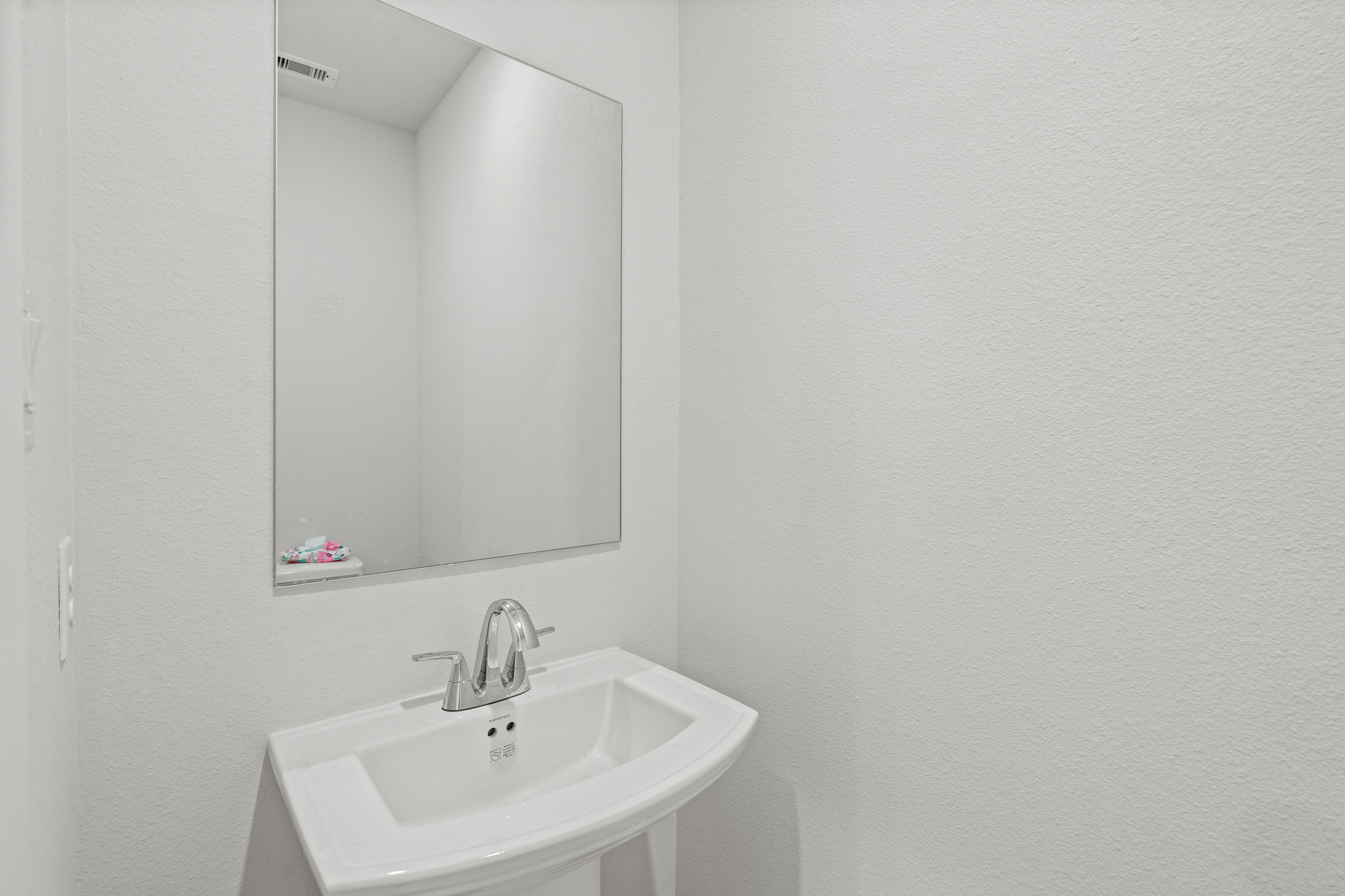 A bathroom with a mirror and sink.