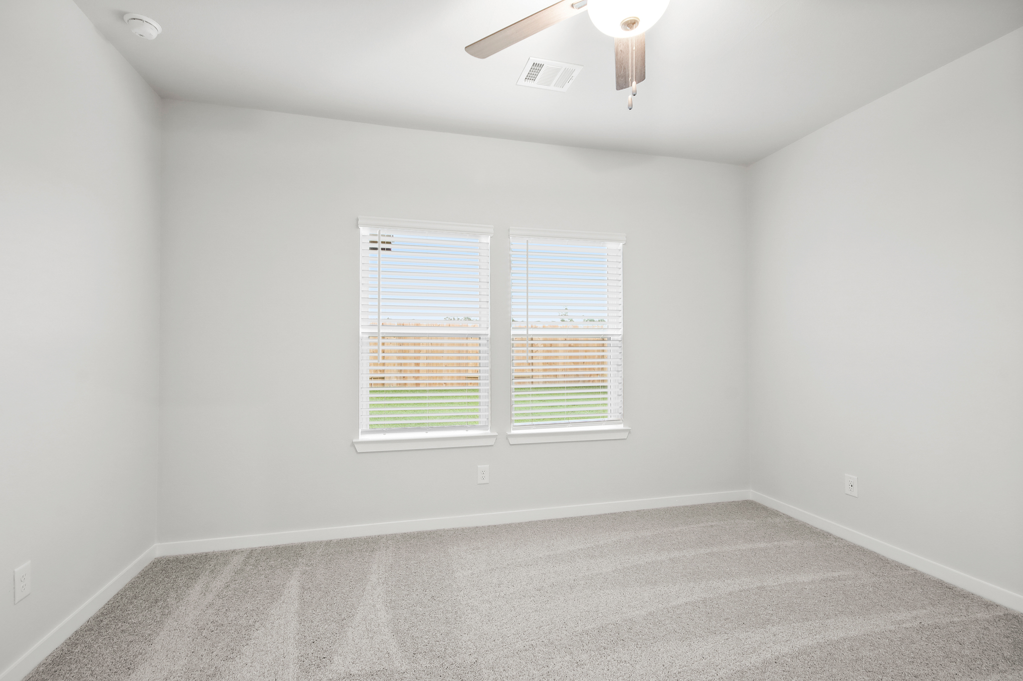 A room with a window and a carpet.