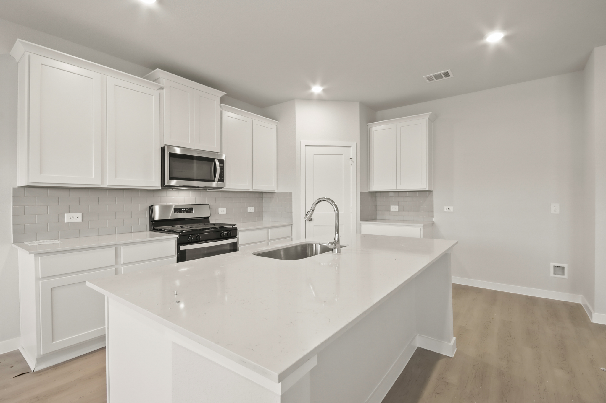 A kitchen with white cabinets.