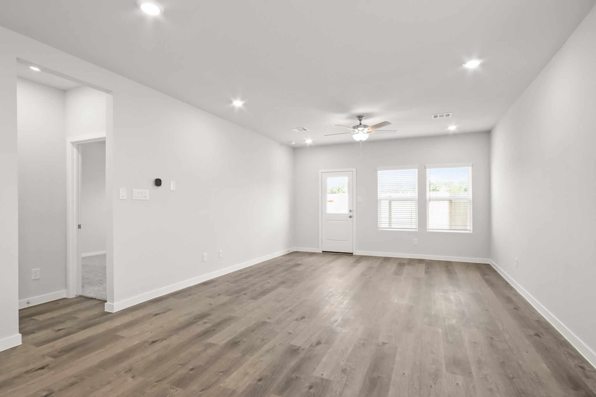 A room with a wood floor and a ceiling fan.